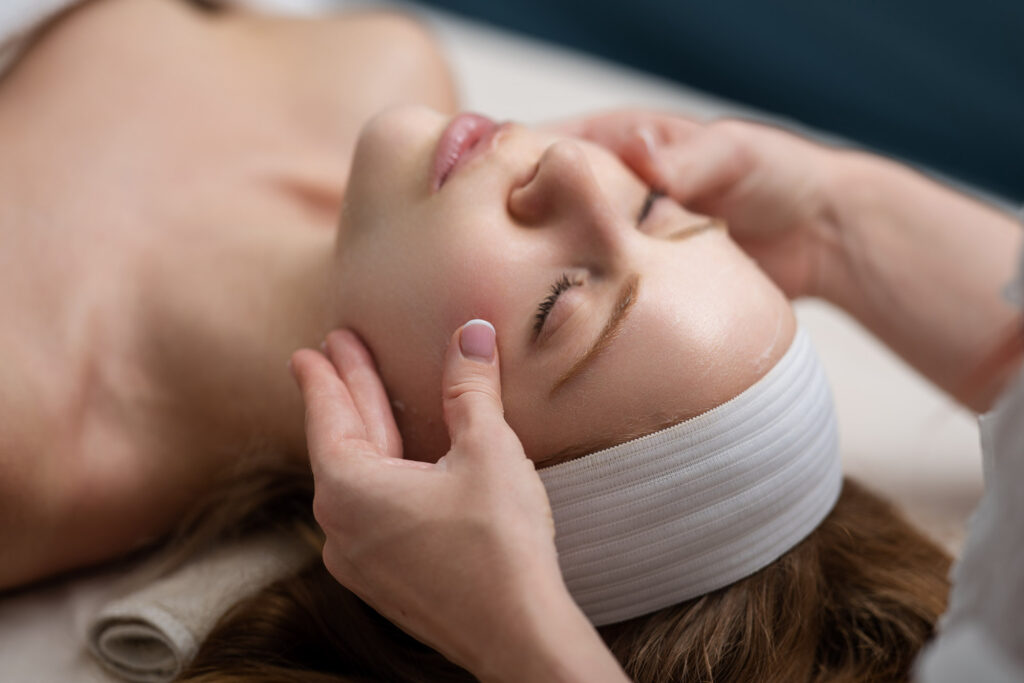 Woman with facial mask. Cosmetic procedure. Beauty spa and cosmetology. Beauty treatments. Facial lifting in SPA salon. Cosmetologist girl does facial massage. Cosmetic procedure. Beauty cosmetology.